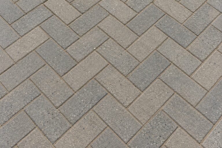 AI generated close view of grey rectangular pavers in a herringbone pattern